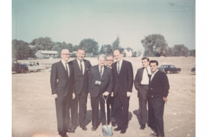 A group of men posing with a shovel at the groundbreaking ceremony for the Haverhill campus.